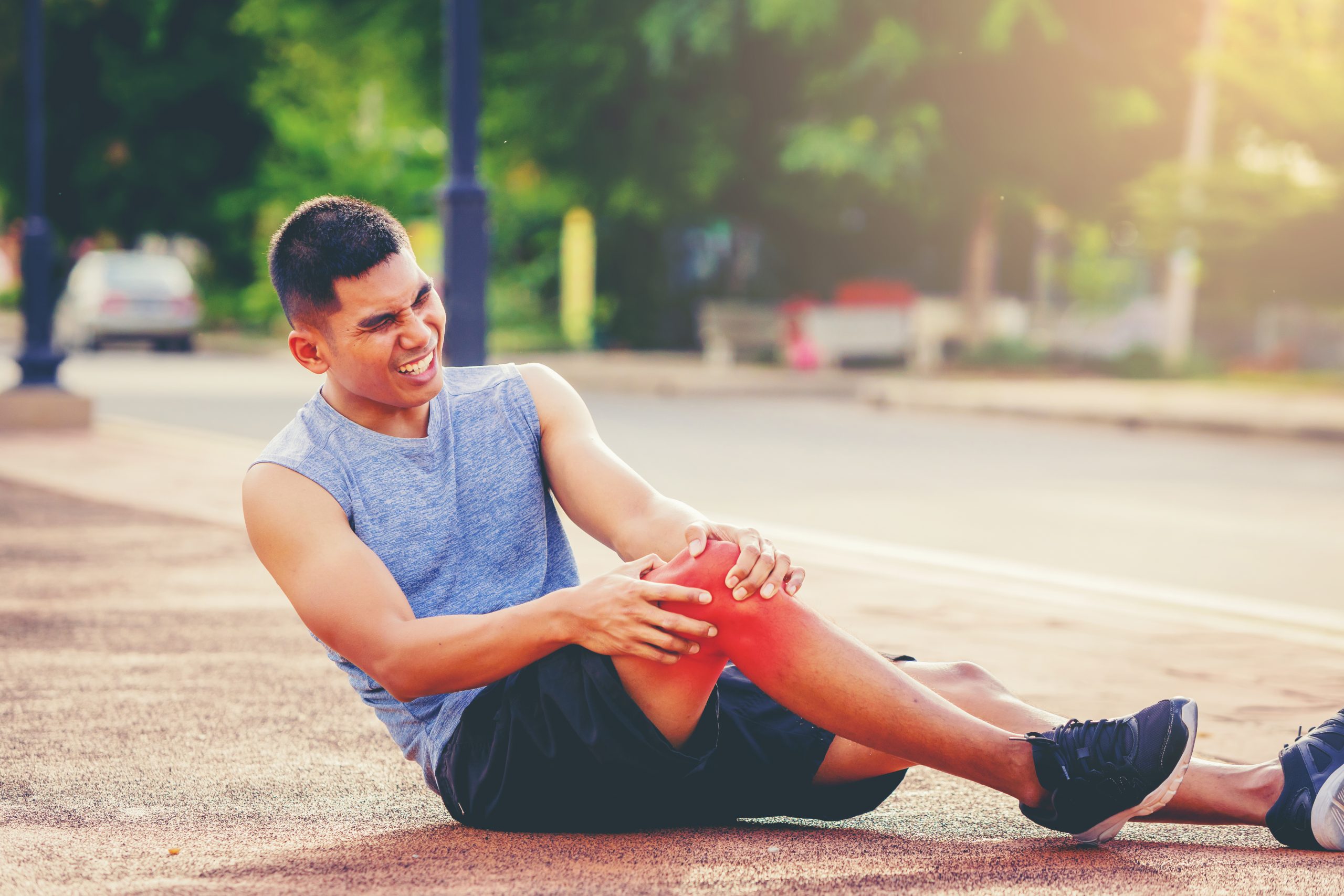Runner man with sports running knee injury. Hands holding knee w